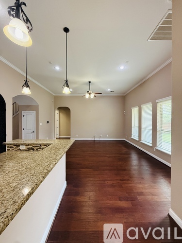 A spacious room with wooden floors and a marble countertop.
