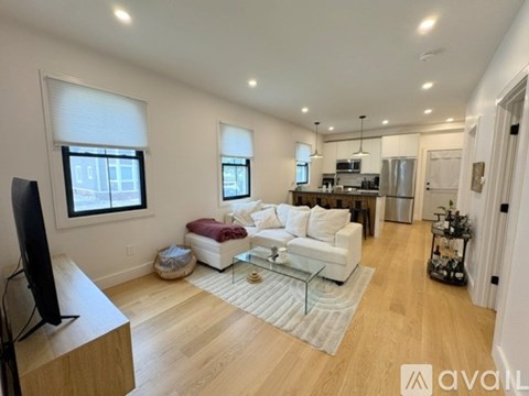 A living room with a white couch and a television.