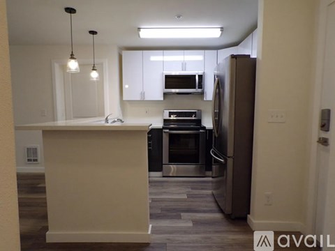 A kitchen with a refrigerator, oven, and microwave.