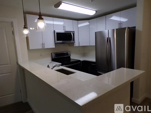 A kitchen with a white countertop and stainless steel appliances.