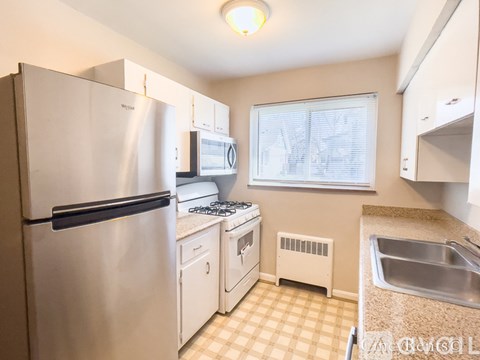A kitchen with a white refrigerator, a white oven, and a white microwave.
