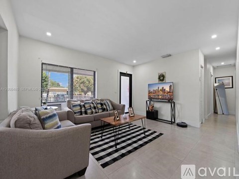 A living room with a couch, a coffee table, and a painting on the wall.