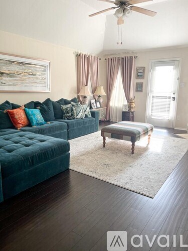A living room with a green couch and a rug.