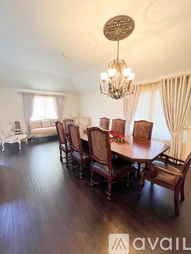 A dining room with a large table and chairs.