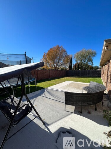 A backyard with a hot tub and patio furniture.