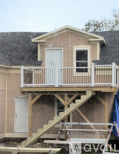 A house under construction with a balcony and stairs.