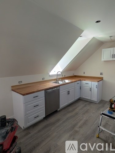 A kitchen with white cabinets and a wooden countertop.