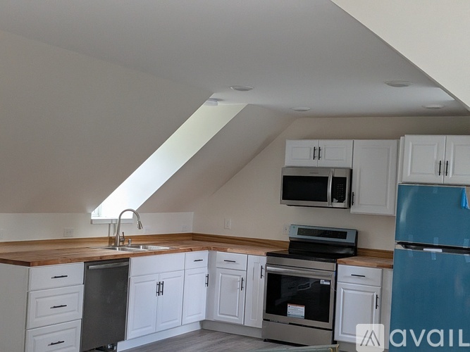 A kitchen with white cabinets and a blue fridge.