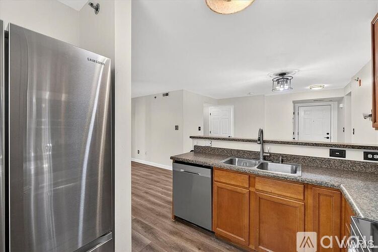 A kitchen with a stainless steel refrigerator and wooden cabinets.