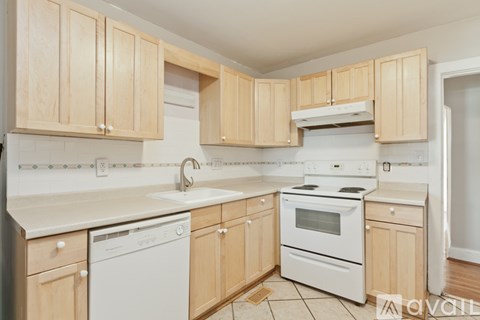 A kitchen with wooden cabinets and white appliances.
