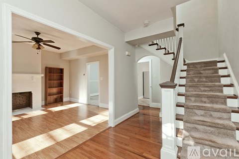 A spacious room with a staircase leading to the upper floor.