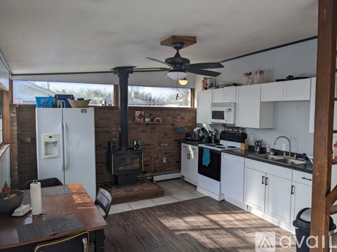 A kitchen with a wood stove and a refrigerator.