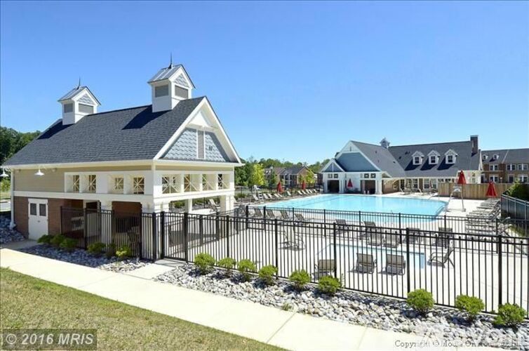A house with a pool in front.