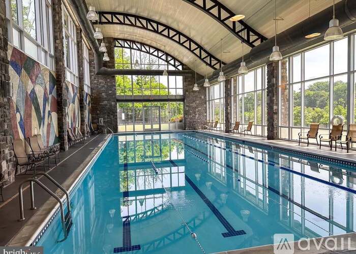 A large indoor swimming pool with a glass wall on one side.