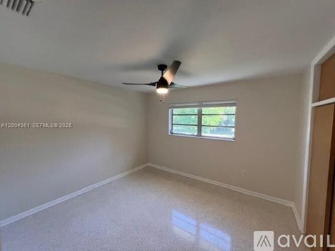 A room with a ceiling fan and a window.