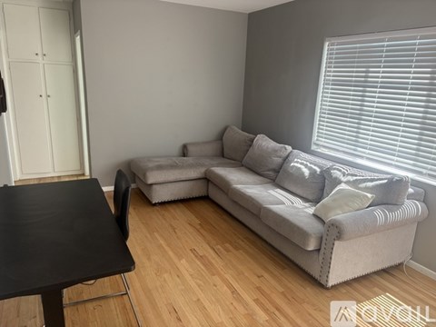 A living room with a grey couch and a black table.