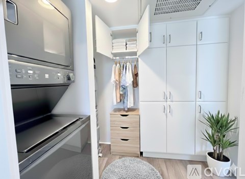 A modern kitchen with a stainless steel oven and white cabinets.