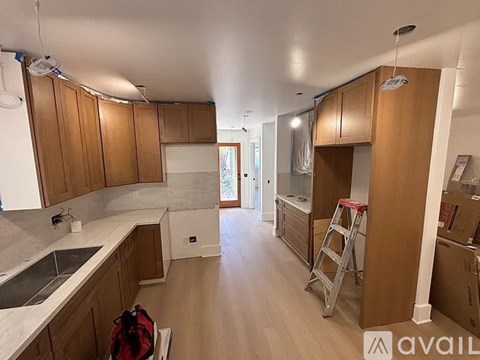 A kitchen with wooden cabinets and a ladder.