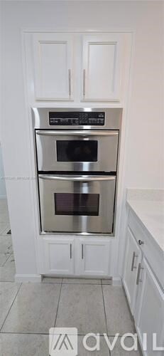 A white kitchen with a double oven built into a cabinet.