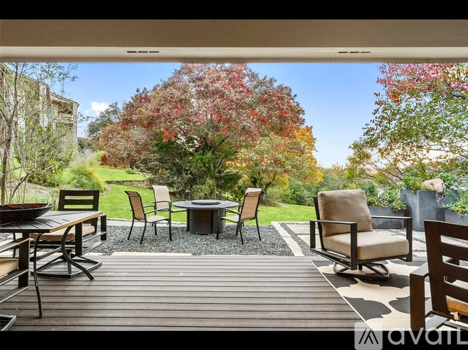 A patio with a table and chairs surrounded by trees.