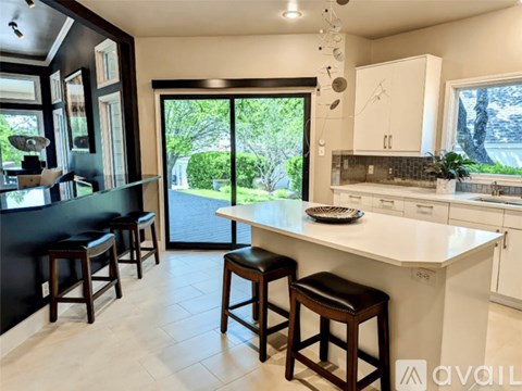 A kitchen with white cabinets and a black countertop.