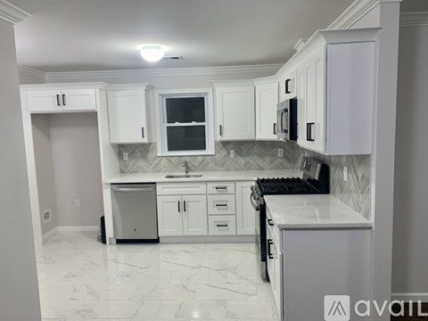 A kitchen with white cabinets and a marble countertop.