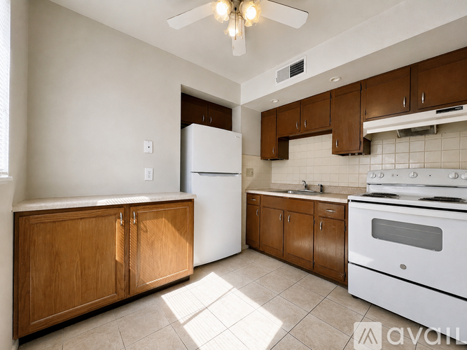 A kitchen with white appliances and wooden cabinets.