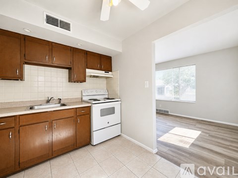 A kitchen with brown cabinets and white appliances.