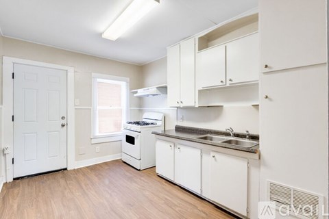 A kitchen with white cabinets and appliances.