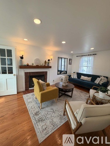 A living room with a yellow chair and a fireplace.
