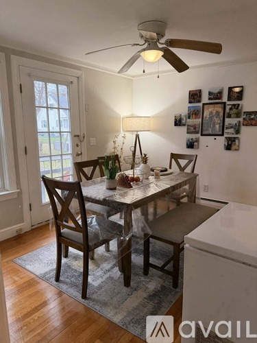 A dining room with a table set for two and a ceiling fan.