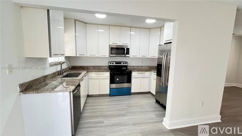 A kitchen with white cabinets and a blue island.