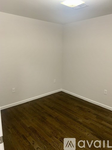 A room with wooden flooring and white walls.