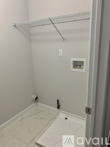 A white bathroom with a toilet and a shelf above it.