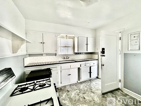 A kitchen with white cabinets and a black stove top.
