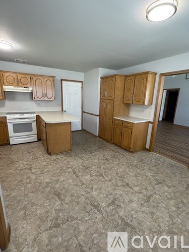 A kitchen with wooden cabinets and a tiled floor.