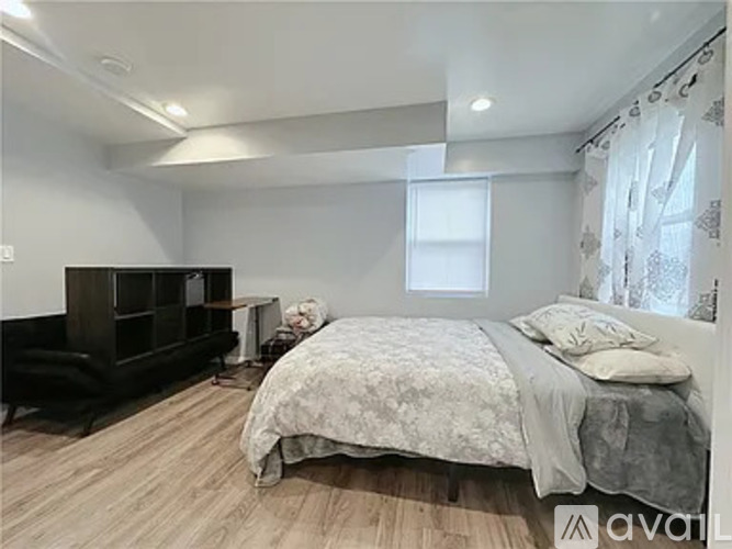 A bedroom with a large bed and a wooden floor.