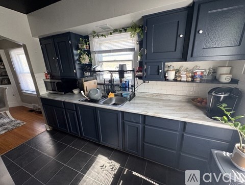 A kitchen with dark cabinets and a marble countertop.