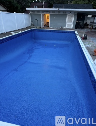 A blue swimming pool in a backyard.