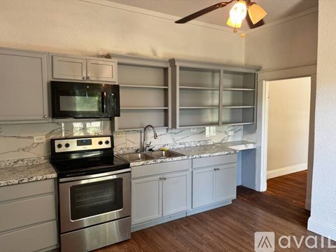 A kitchen with a stove, microwave, and oven.