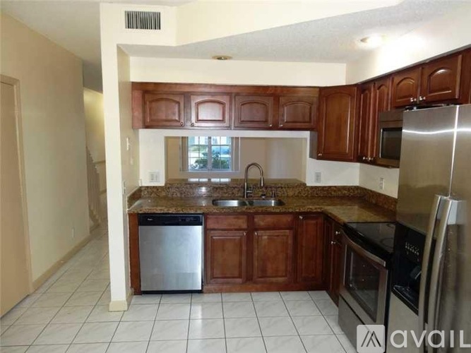 A kitchen with brown cabinets and stainless steel appliances.