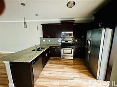 A kitchen with a refrigerator, oven, and microwave.