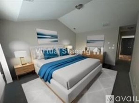 A bedroom with a bed, nightstand, and lamp.
