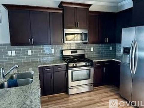 A kitchen with dark wood cabinets and a stainless steel refrigerator.