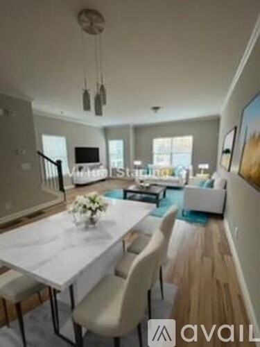 A modern dining room with a white table and chairs.