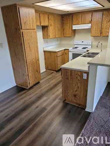 A kitchen with wooden cabinets and a white stove top oven.