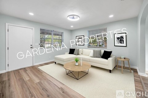 A living room with a white sofa and a coffee table.