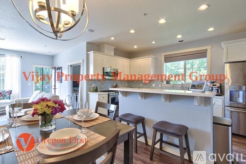 A well-lit kitchen with a dining table set for two.