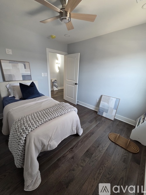 A bedroom with a bed, a ceiling fan, and a rug.