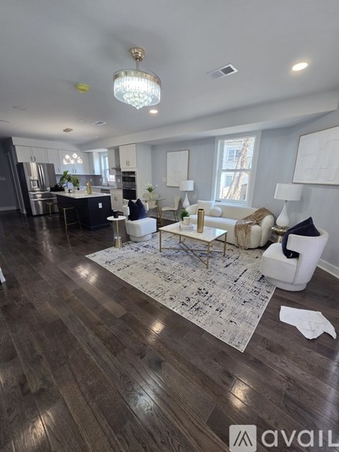A well-lit living room with a large rug and a sofa.